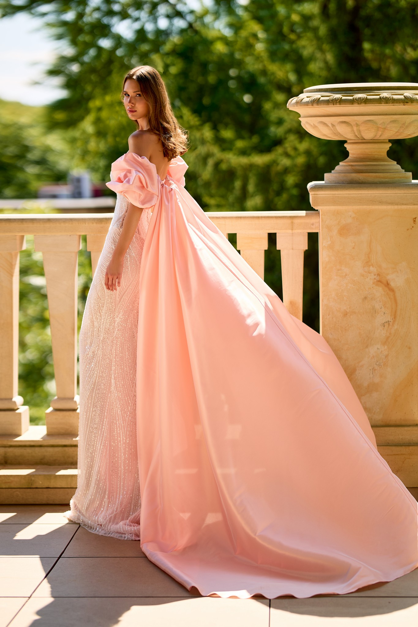 Fitted evening gown with long cape and shimmering lace embroidery