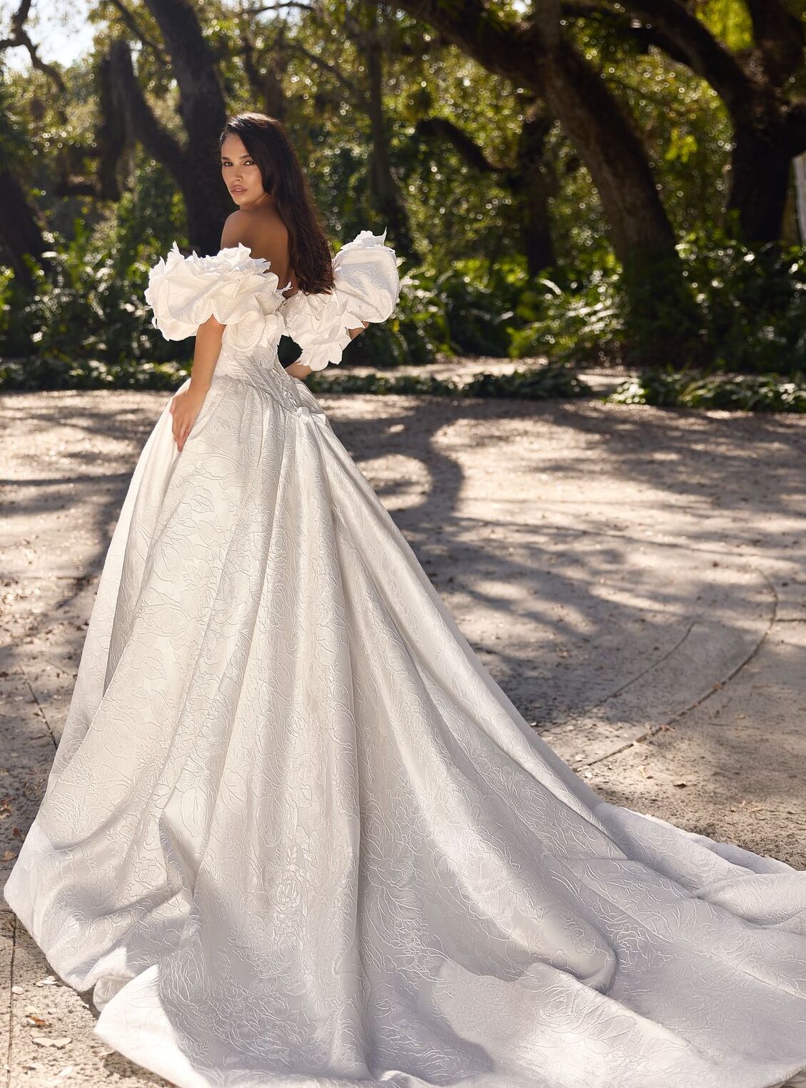 Regal Edvina bridal gown with full patterned skirt and handmade flower details.